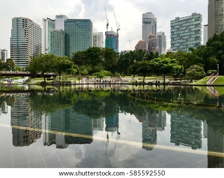 Reflections of buildings  seen on a hot sunny day in Kuala Lumpur Royalty-Free Stock Photo #585592550