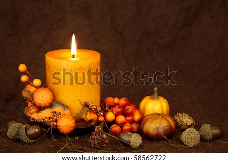 Autumn candle on a brown backdrop