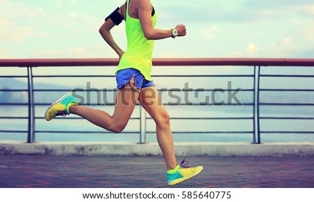 healthy lifestyle young fitness woman running at seaside Royalty-Free Stock Photo #585640775