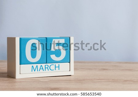 March 5th. Day 5 of month, wooden color calendar on table background. Spring time, empty space for text