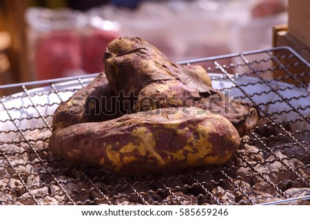 Close up photo image of sweet potato on a grid iron grill by charcoal sell in a organic food market, rustic style of cooking