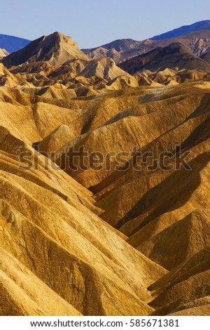 The beautiful erosional features of Zabriskie Point which is a part of the Amargosa Range located east of Death Valley in Death Valley National Park in California, Royalty-Free Stock Photo #585671381