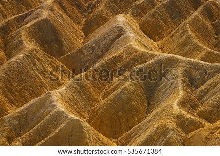 The beautiful erosional features of Zabriskie Point which is a part of the Amargosa Range located east of Death Valley in Death Valley National Park in California, Royalty-Free Stock Photo #585671384