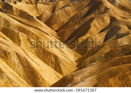 The beautiful erosional features of Zabriskie Point which is a part of the Amargosa Range located east of Death Valley in Death Valley National Park in California, Royalty-Free Stock Photo #585671387