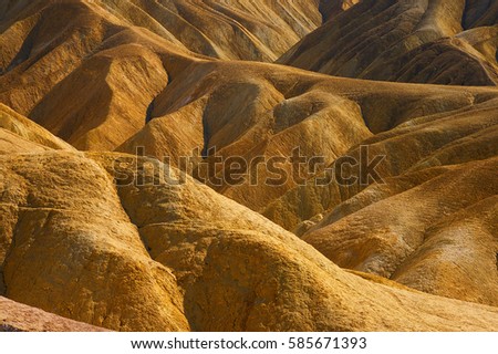 The beautiful erosional features of Zabriskie Point which is a part of the Amargosa Range located east of Death Valley in Death Valley National Park in California, Royalty-Free Stock Photo #585671393