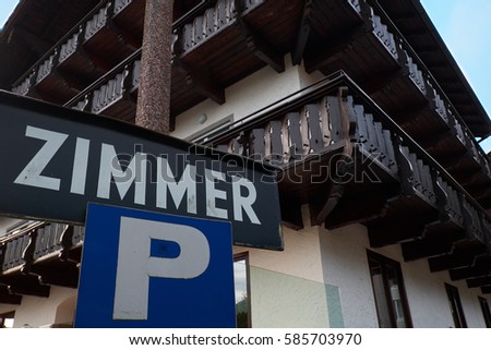 Sign Zimmer with chalet background in Alps