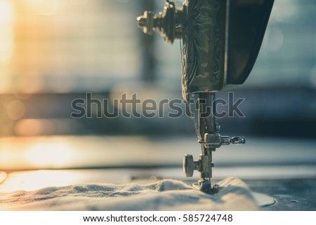 Closeup the sewing machine and item of clothing, old sewing machine,vintage style Royalty-Free Stock Photo #585724748