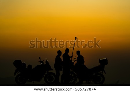 silhouette of people practicing yoga on the mountain at sunset
