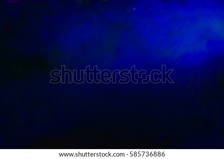Blue colored smoke in the dark, dark background