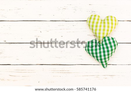 Greeting card background with two green hearts on white wood with copy space.