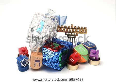 Many Dreidals (tops), candle dreidals and small hannukia (Menorah or candelabra) grouped together against a white background