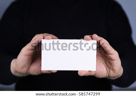 a small white piece of paper in his hand man