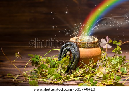 St Patricks day decoration with magic light rainbow pot full gold coins, horseshoe and shamrocks on vintage wooden background, close up