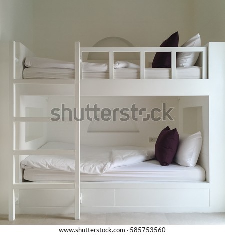 Clean hotel room with wooden bunk beds. Vintage effect style pictures.