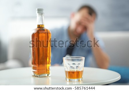Bottle and glass of whisky on white table Royalty-Free Stock Photo #585761444