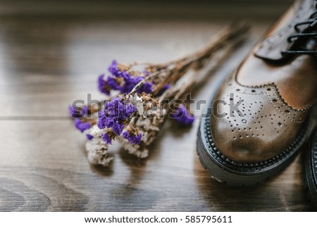 stylish shoes, wild flowers on wooden background, with space for text