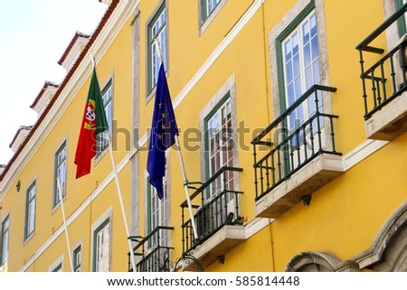 Yellow facade of an ancient building with flags of Portugal and the European Union, Lisbon, Portugal