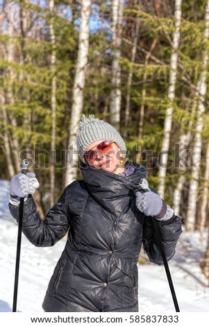 Happy young woman skiing in the winter forest