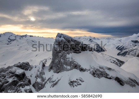 Beautiful aerial landscape view of snow covered mountains with a colorful morning sky. Picture taken of Black Tusk in Garibaldi, British Columbia, Canada.