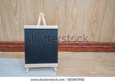 empty black board on wooden floor and wall background for your text design. 