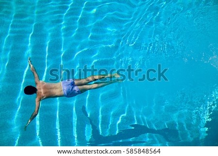 Young man diving into swimming pool
