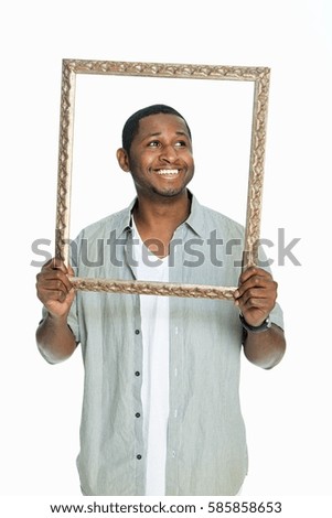 Mid adult man smiling through picture frame against white background