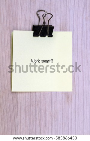 Motivational word quotes on sticky memo paper with wooden background.