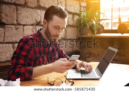 Handsome young man working on computer at cafe