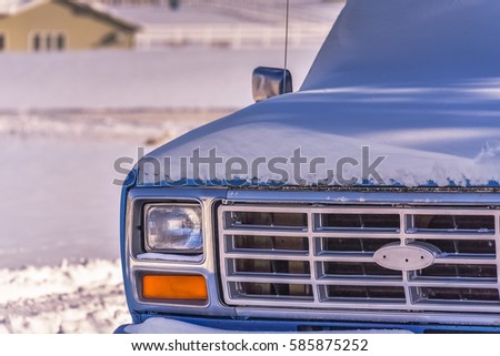 The Old Blue pickup truck covered with snow. Closeup. Rural landscape. Winter in Wyoming, USA