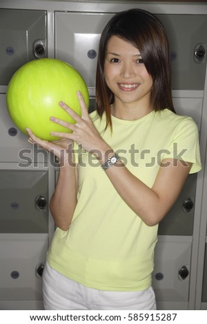 Woman holding bowling ball, smiling