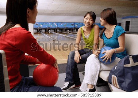 Women sitting in bowling alley