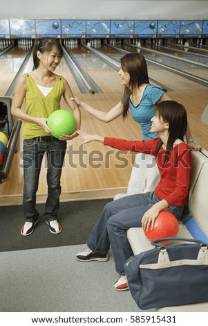 Three women in bowling alley