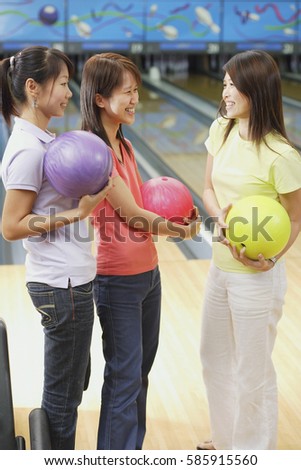 Women at bowling alley, holding bowling balls