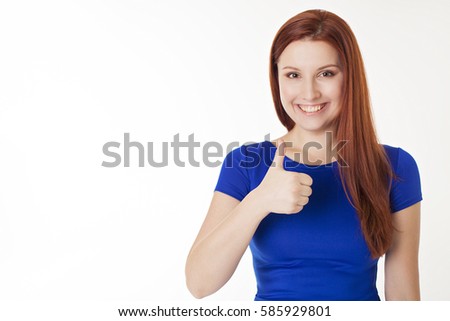 Portrait of a beautiful young red-haired girl in an elegant blue dress she laughs and shows her right hand great on a white background isolated. The concept of billboard.