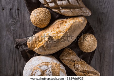 Several types of fresh bread lying on an old wooden table