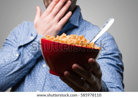 surprised young man holding a corn flakes bowl