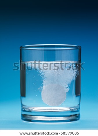 closeup of painkiller tablet in glass of water. Vertical shape, copy space