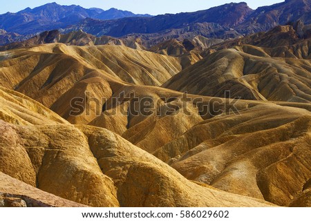The beautiful erosional features of Zabriskie Point which is a part of the Amargosa Range located east of Death Valley in Death Valley National Park in California, Royalty-Free Stock Photo #586029602