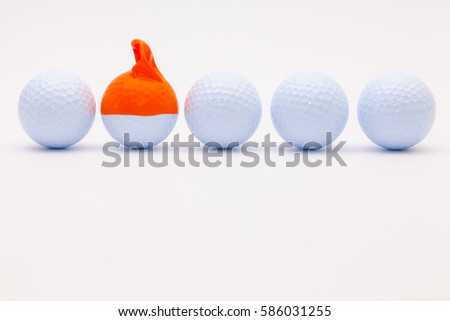 White golf balls with funny cap on the white background. Funny golf concept.