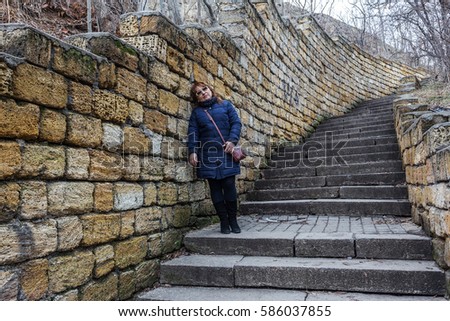 Ancient stone staircase, framed by a stone wall of natural stone limestone. Old stone sloping long staircase on the hillside