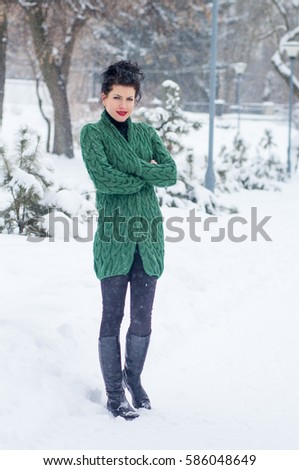 Beautiful girl in a green cardigan winter background