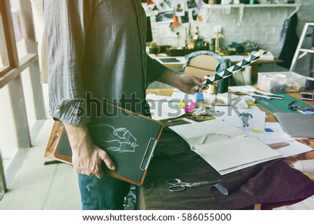 Fashion designer holding clipboard of dress pattern