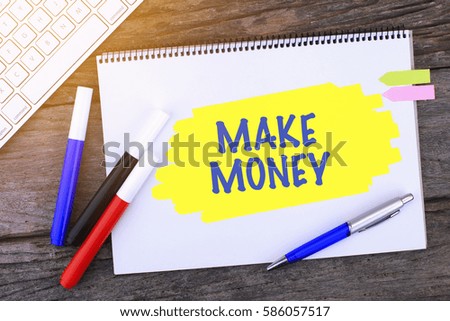 Notebook with MAKE MONEY Handwritten on wooden background and Modern Computer Keyboard. Top View Composition