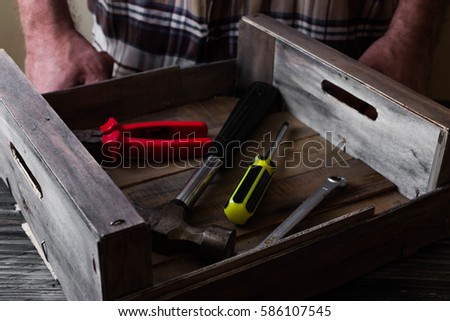 Man with Hand tools on a wooden table in rustic style