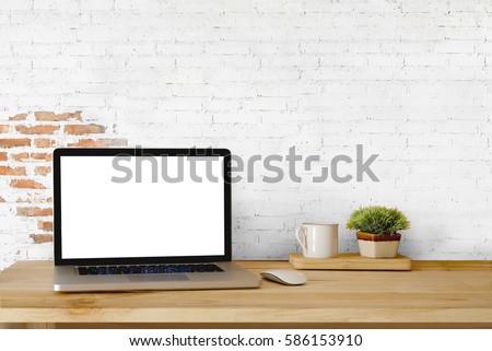 Mock up Blank Screen Laptop on wood table and white brick wall.