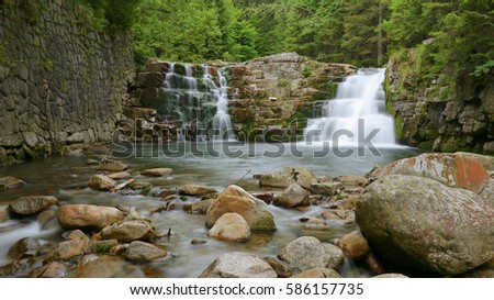 Double waterfall in the forest mountain valley