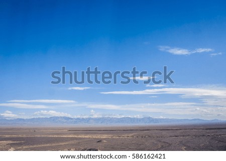 Barren landscape with distant mountains in Xinjiang Province, China