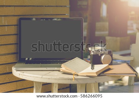 Mockup image of laptop with blank white screen on wooden table