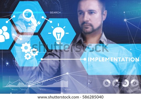 Business, Technology, Internet and network concept. Young businessman shows the word on the virtual display of the future: Implementation