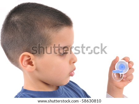 Little boy blowing soap bubbles - white background studio image.